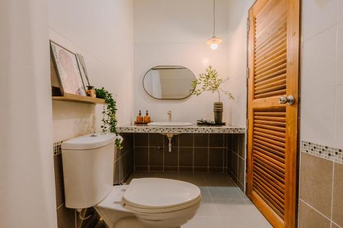 a bathroom with a toilet and a sink at Kawish House กาวิส เฮ้าส์ in Ban Hua Trut