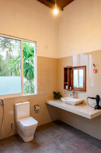 a bathroom with a toilet and a sink and a window at AnuBi Nest Ella in Ella