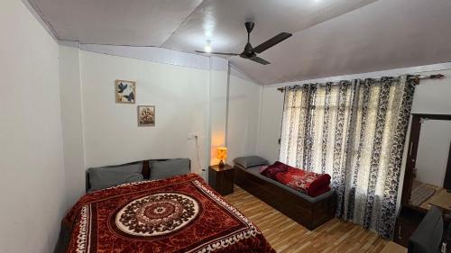 a bedroom with a bed and a ceiling fan at Chotlung BNB in Bijanbāri Bāzār
