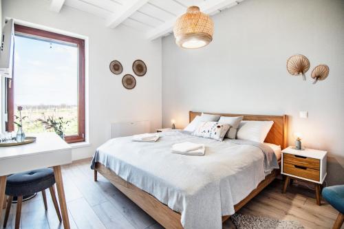 a bedroom with a bed and a desk and a window at Bandi Weekend House in Somlójenő