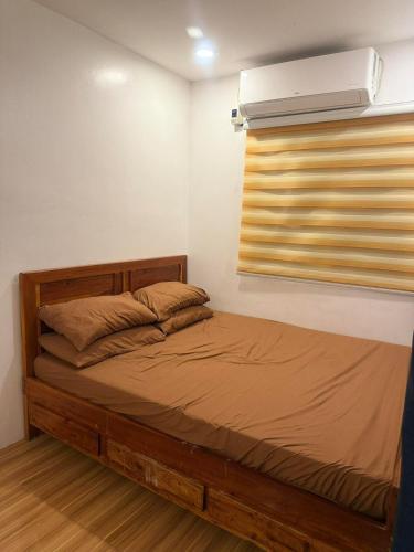 a bedroom with a bed and a window with a air conditioner at Homestay in Lipa City in Lipa