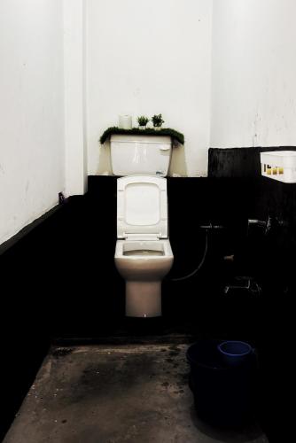a bathroom with a toilet in a dark room at Chotlung BNB in Bijanbāri Bāzār
