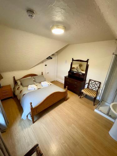 a bedroom with a bed and a mirror and a chair at Ythanview Hotel in Methlick