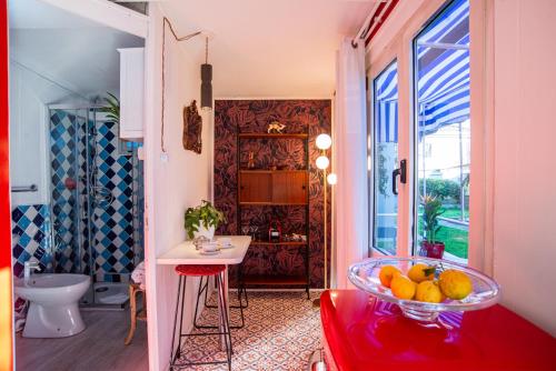 a bathroom with a red stool and a bowl of fruit at Atelier Randagi al Pigneto 1&2 in Rome