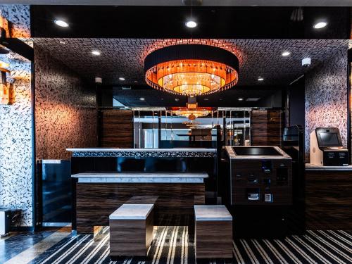 a bar in a restaurant with a large chandelier at APA Hotel Himeji Ekikita in Himeji