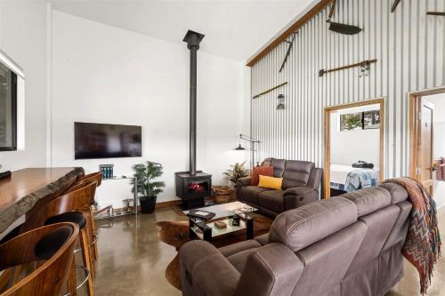 a living room with a couch and a fireplace at Rosa Glen Retreat - Farm Stay, Margaret River in Rosa Glen