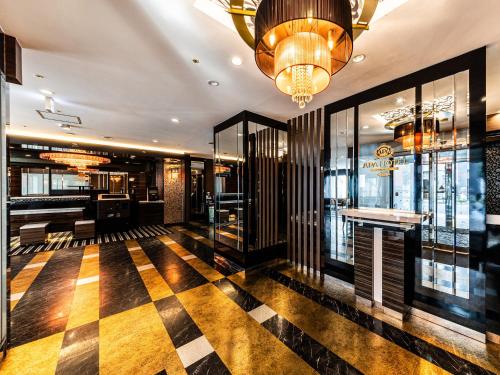 a restaurant with a checkered floor and a chandelier at APA Hotel Himeji Ekikita in Himeji