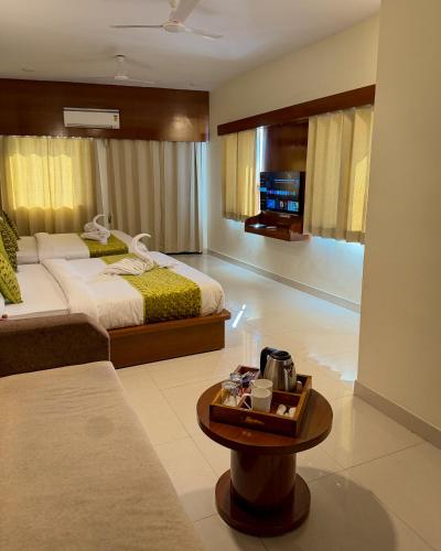 a hotel room with two beds and a table at New Crown Plaza in Jodhpur