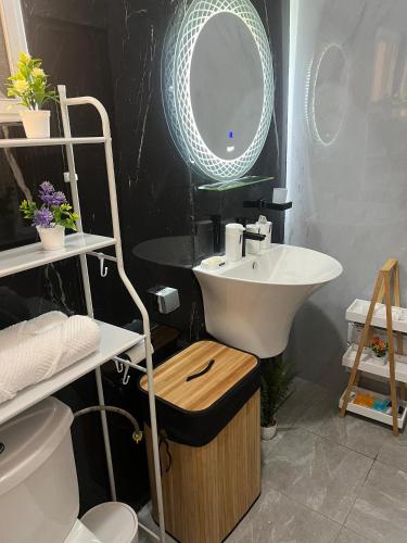 a bathroom with a sink and a mirror at Bungo Home - Suite Chambre & salon à 2 min de la plage in Pointe-Noire