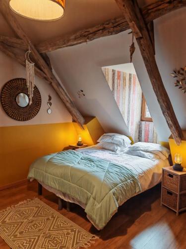 a bedroom with a bed and a yellow wall at Les Girouteaux La bergerie in Les Eyzies-de-Tayac