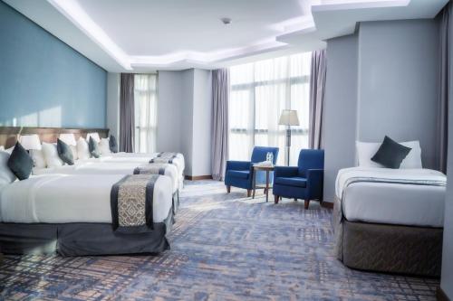 a hotel room with two beds and two chairs at Maien Taiba in Medina