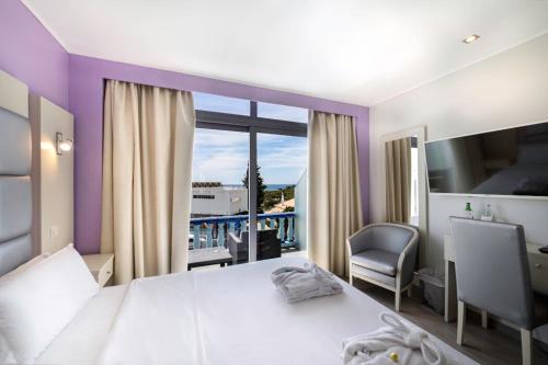 a bedroom with a large white bed and a window at Hotel Santa Eulália Bay - Adults Only in Albufeira