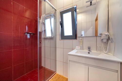 a bathroom with a glass shower and a sink at Hotel Santa Eulália Bay - Adults Only in Albufeira