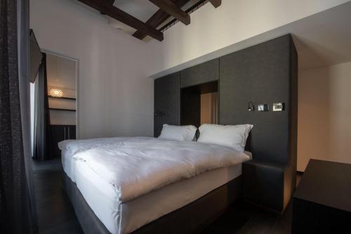 a bedroom with a large bed with a black headboard at Suite Apartments by Hotel Gabbani in Lugano