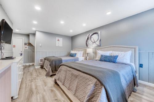 a bedroom with two beds and a flat screen tv at Sea Treasures Inn #104 in Rockaway Beach