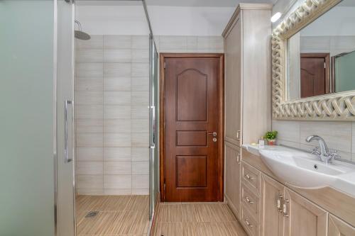 a bathroom with a shower and a sink and a mirror at Villa Chrysseva in Plátanos