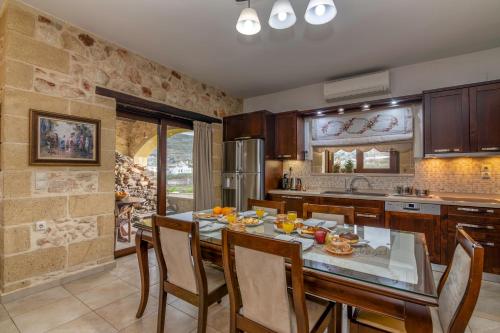 een keuken met een tafel en stoelen in een kamer bij Villa Chrysseva in Plátanos