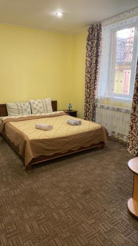 a bedroom with a bed with two towels on it at Вілла Верховина in Skhidnitsa