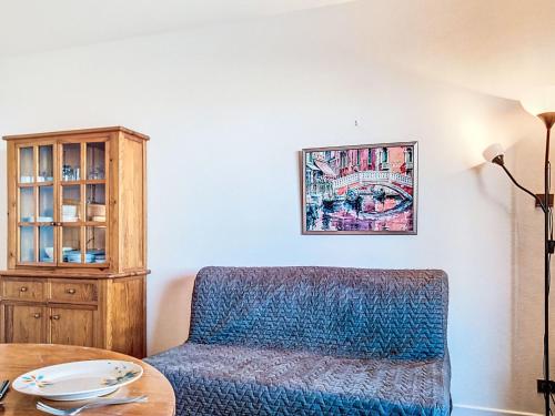 a living room with a blue chair and a table at Apartment Horizon Marin-2 by Interhome in Lacanau-Océan