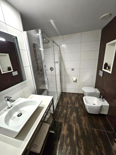 a bathroom with a sink and a shower and a toilet at Gran Hotel Botánicos in Teruel