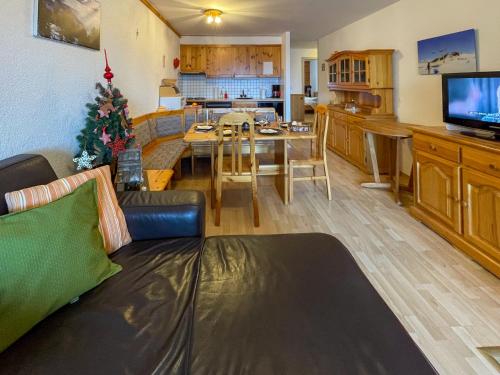 a living room with a couch and a dining room at Apartment Hauts de Nendaz BI3 by Interhome in Nendaz