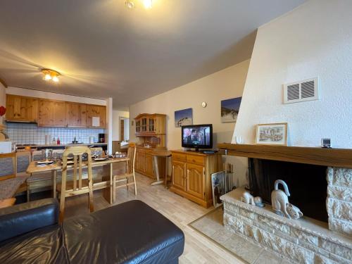 a living room with a fireplace and a dining room at Apartment Hauts de Nendaz BI3 by Interhome in Nendaz