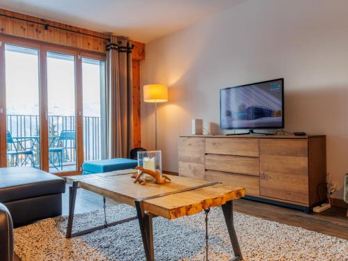 a living room with a tv and a coffee table at Apartment Chaedoz 24-1 by Interhome in Nendaz