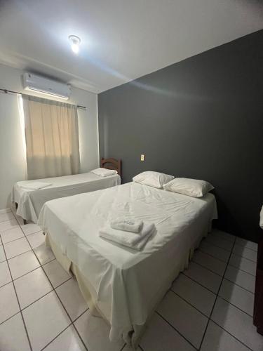 two beds in a hotel room with towels on them at Hotel e Pousada Recanto do mar in Florianópolis