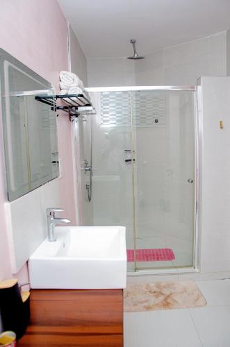 a bathroom with a sink and a shower at EXCLUSIVE ANSO Homes GRA Ikeja 1 bed room in Ikeja