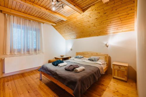 a bedroom with two beds and a wooden ceiling at Noszvaj Elite Apartman in Noszvaj