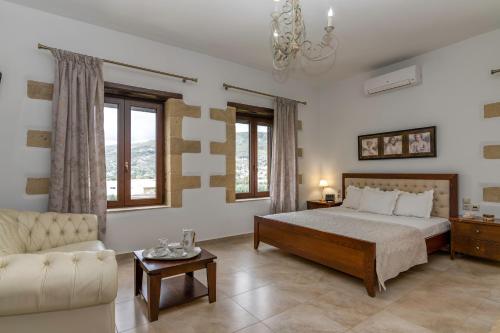 a large bedroom with a bed and a couch at Villa Chrysseva in Plátanos