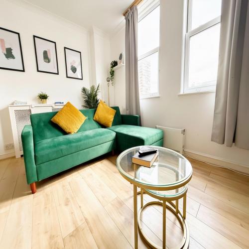 a living room with a green couch and a glass table at Serene Ocean Side Apartment BTN in Brighton & Hove