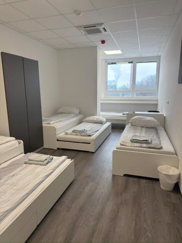 ein Zimmer mit drei Betten und einem Fenster in der Unterkunft DRIVER ROOMS in Nürnberg
