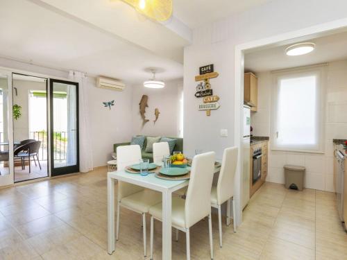 a kitchen and dining room with a white table and chairs at Apartment Mitsu by Interhome in Tossa de Mar