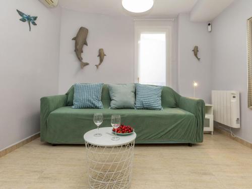 a living room with a green couch and a table at Apartment Mitsu by Interhome in Tossa de Mar