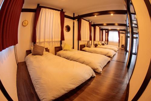 a row of beds in a room with a mirror at La Station in Bibai