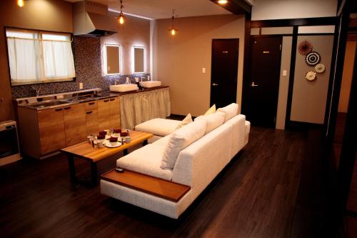 a living room with a white couch and a table at La Station in Bibai