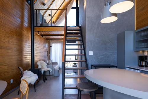 a spiral staircase in a room with a table and chairs at Cabanas Horizonte Cambará Nature in Cambará