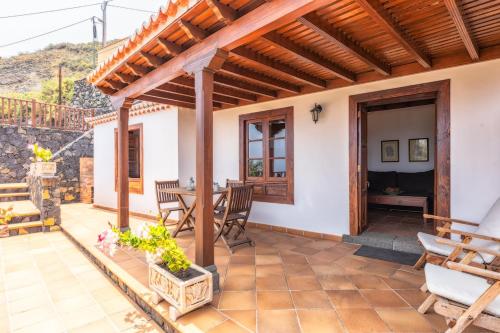 a patio with a wooden pergola and a table and chairs at Guestready - La Morita Villa de Mazo in Mazo