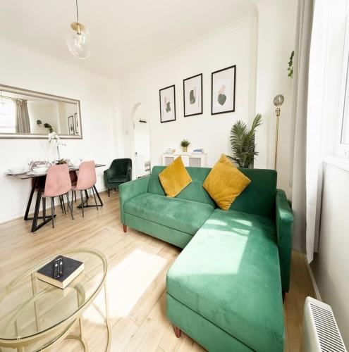 a living room with a green couch and a table at Serene Ocean Side Apartment BTN in Brighton & Hove