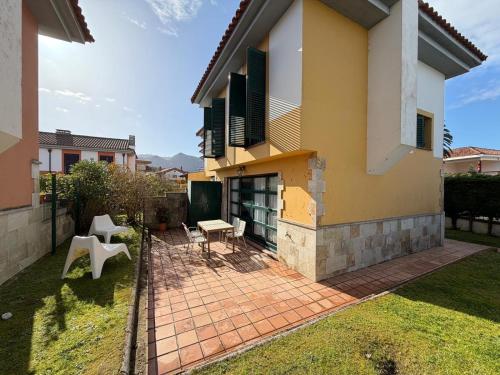 a house with a patio with a table and chairs at Cala Tatina in Celorio