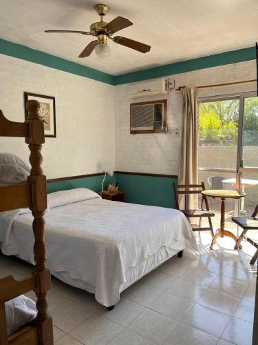 a bedroom with a bed and a bathroom with a tub at Hotel Village Termas de Dayman in Termas del Daymán