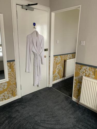 a robe hanging on a door in a room at Neptunes Rest Guest Hotel in Stranraer