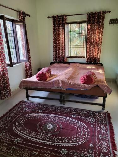 a bed in a room with a rug and two windows at Commander's Home in Kangra