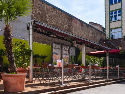 a restaurant with tables and chairs in front of a building at Ballhaus Berlin Hostel in Berlin