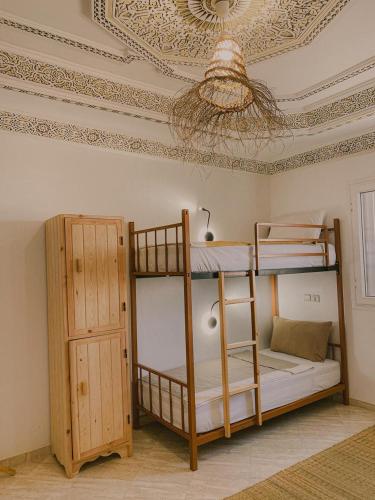 a room with two bunk beds and a ceiling at Dania Surf House in Mirleft