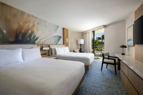 a hotel room with two beds and a desk at Waikoloa Beach Marriott Resort & Spa in Waikoloa