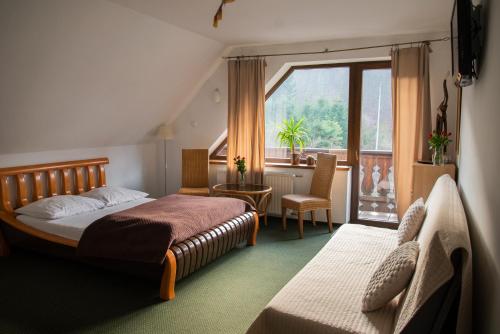a hotel room with a bed and a window at Willa Pod Dobrym Humorem in Miedzygorze