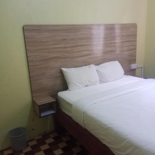 a bedroom with a large bed with a wooden headboard at MSL Suites Apartment in Naivasha