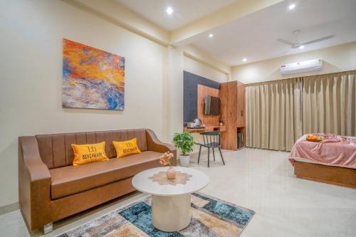a living room with a couch and a table at Benchmark Residences in Indore